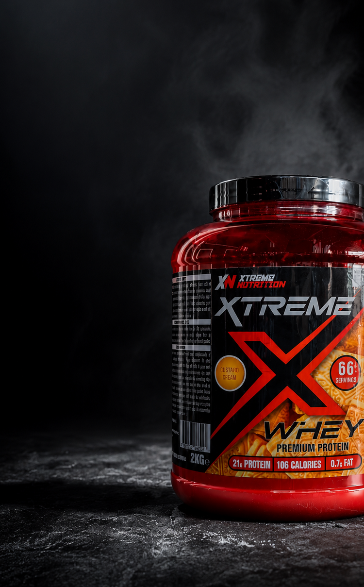 A red tub of Xtremes Nutrition Whey protein powder sits on a dark textured surface with dramatic smoke rising from it. The label is black and red with white text, and the product is shown in a moody studio setting.